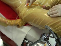 Gimp in latex bondage endures cock and balls punishment