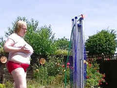 Big granny breasts getting soaked in the garden