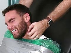 Bearded stud restrained to have his bare feet playfully tickled