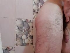 Handsome muscular hairy guy takes a shower.