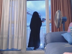 veiled muslim displays off in front of a crane operator