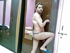 Sexy sissy crossdresser femboy Sweet Lollipop in a bra-thong, hairband and flip-flops.