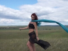 Mature exotic dancer enjoys windy weather atop a hill in Russia