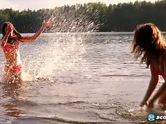 Margo Von Teese and Simona splash each other in their bikinis in a lake before eating each other out on the beach.