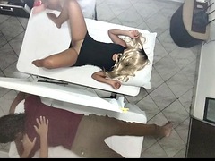 Erotic massage on the body of the beautiful wife next to her husband in the couples massage parlor, it was recorded