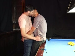 Two men with big cocks are banging a lad on the table