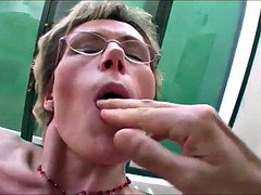 Granny in glasses takes two young cocks