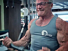 Ripped mature bodybuilder flexes muscles and shows off veins
