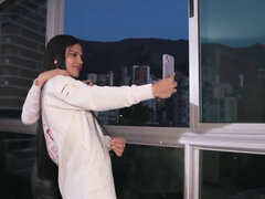 Two remarkable brunettes having lesbian sex by the window