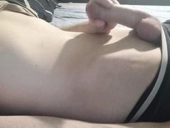 The guy enjoys stroking his hard member while lying on the bed