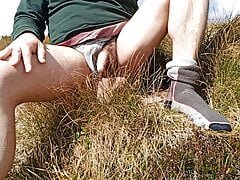 Pissing open air in the mountain on the grass.