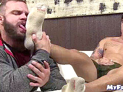 tattooed hunk receives feet tonguing while draining