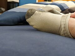 Bear cub taking off socks after long day at work