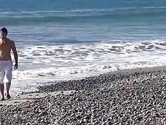 Tanned hunk massages his sausage on the beach