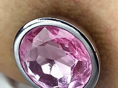 Princess plays with a pink metal buttplug.