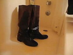 Pissing on brown leather boots in a bathtub
